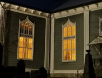 Urjalan kirkon ikkunoista loistaa valoa kirkkomaalle
