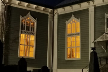 Urjalan kirkon ikkunoista loistaa valoa kirkkomaalle