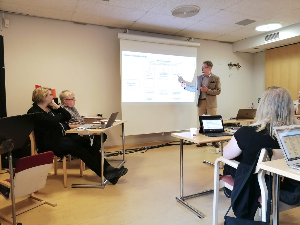 Puheenjohtaja Kari Leinamo ja sihteeri Minna Kuljuntausta katsoivat tarkkaan tileistä heijastettua kuvaa valkokankaalta. Positiivisen tuloksen esitteli talouspäällikkö Aleksi Riuttala. Kokouksessa oli läsnä 11 valtuutettua.